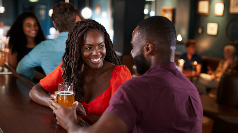 Man and woman talk at a bar