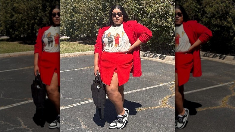 A woman wearing a graphic tee and red skirt