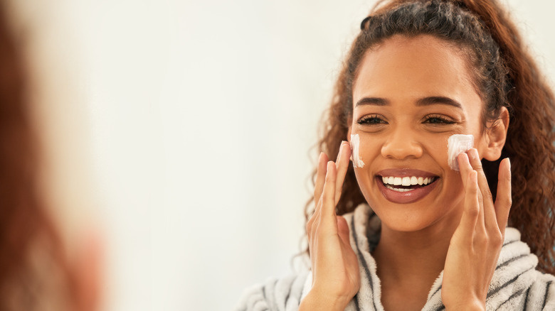 woman applying moisturizer