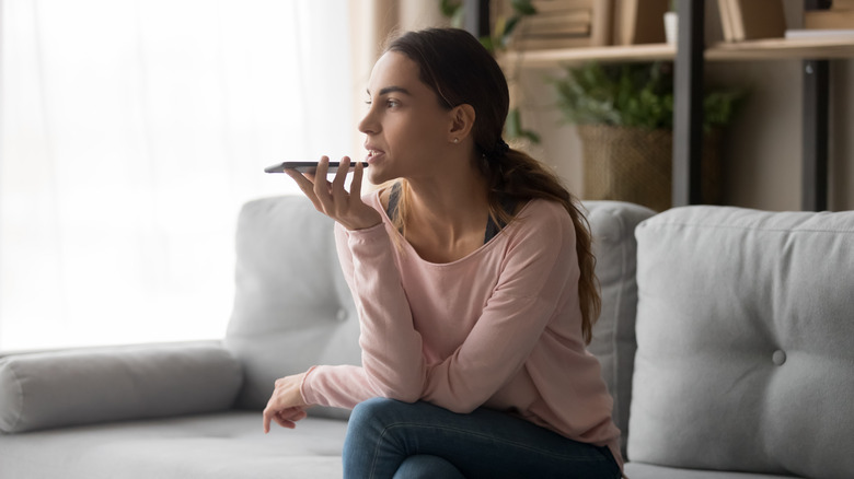 Woman talking into recorder on couch