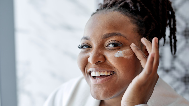 woman applying moisturizer