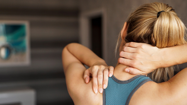 woman holding sore shoulder