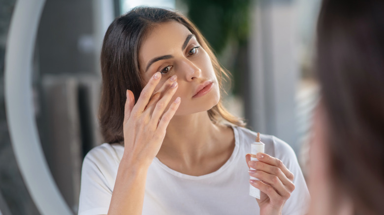 Woman applying concealer