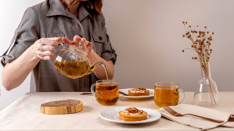 woman pouring green tea with plated treats