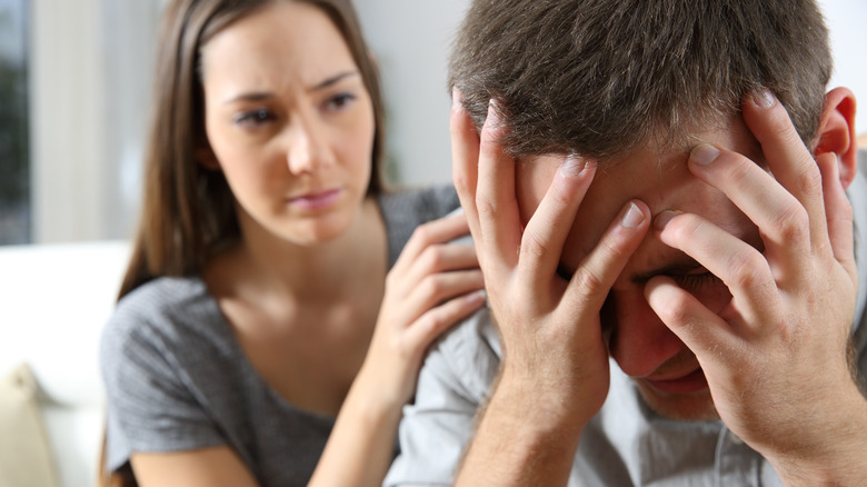 Man crying, woman behind him