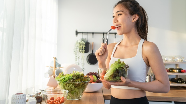 woman eating bowl of vegetables