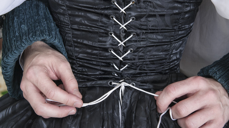 Corset bra being laced up.