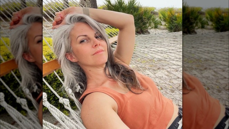 Gray-haired woman reclining in orange