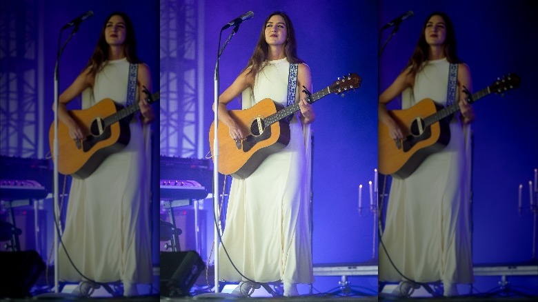 Weyes Blood with guitar in gown