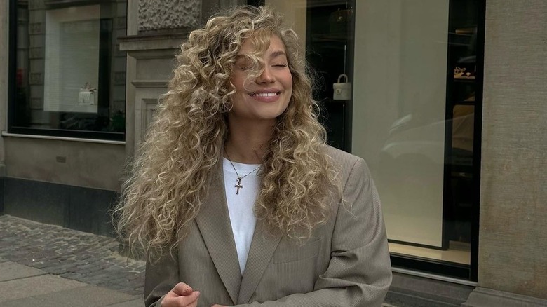 Woman in beige blazer with blond curls