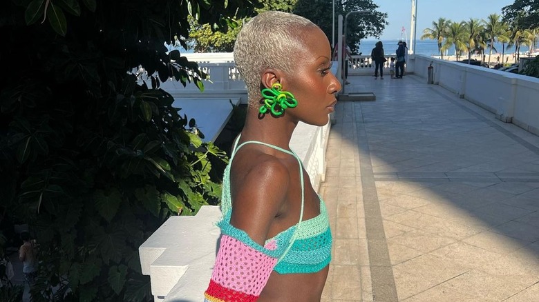Woman with blond hair and neon green earrings