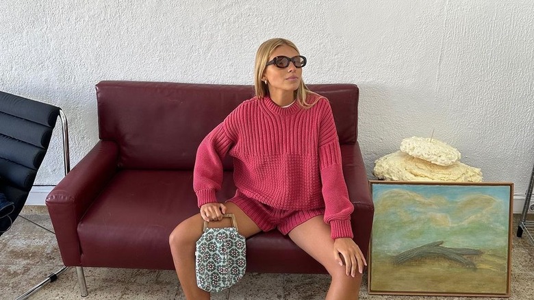 Woman with blond hair in reddish pink knit outfit