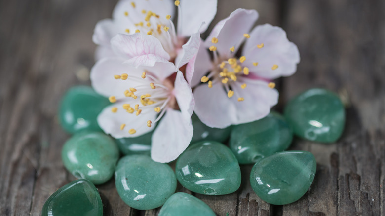 aventurine and pink flowers on wood background