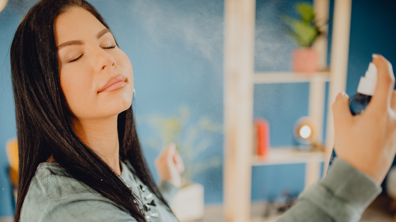 Woman spraying her face