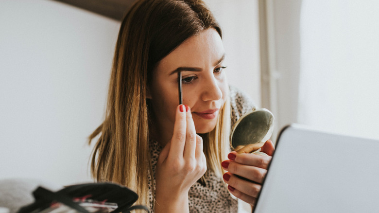 woman applying eyebrow makeup