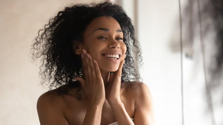 Happy woman looking in mirror