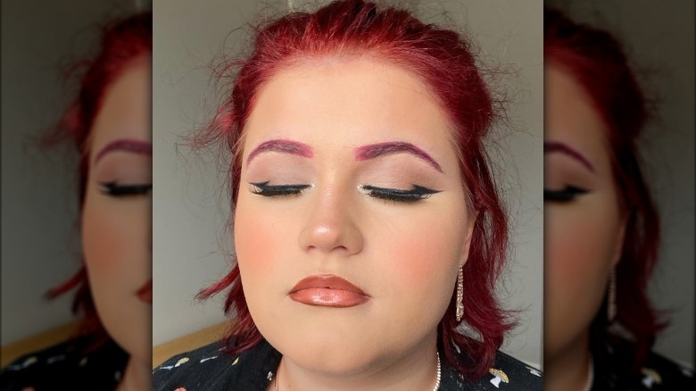 Woman using batwing eyeliner technique