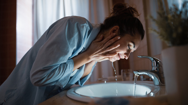 woman washing face at night