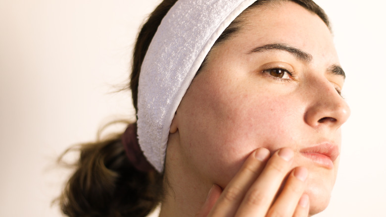 woman examining her skin