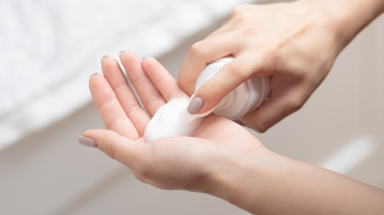 woman pumping cleanser on to hand