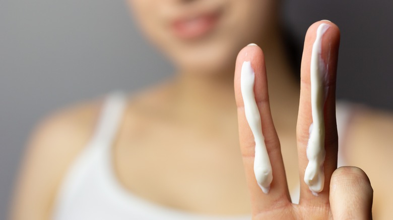 woman with sunscreen on fingers