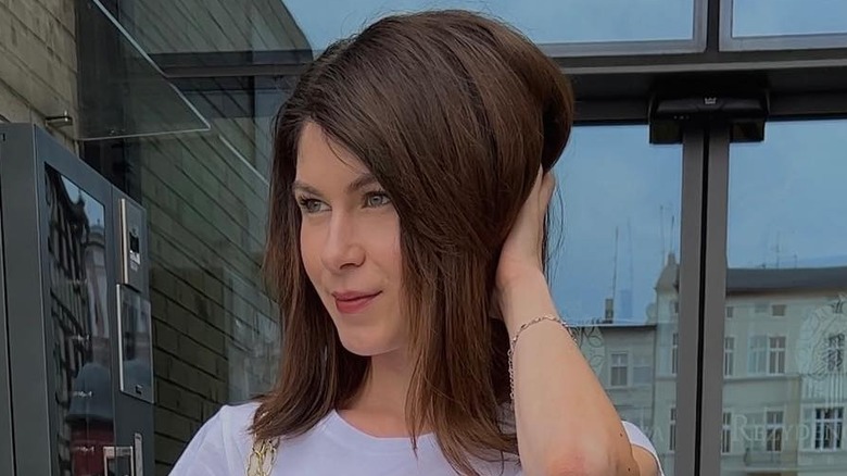 brunette woman touching hair