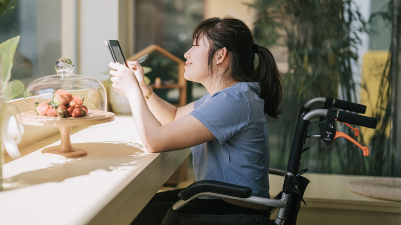 Woman in wheelchair using e-reader