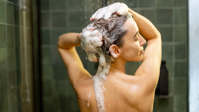 woman applying shampoo in shower