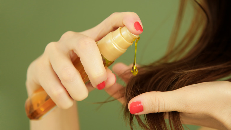 woman applying hair oil