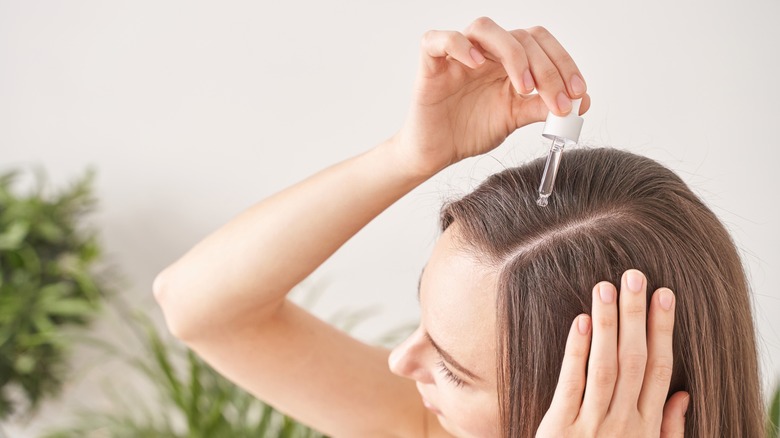 woman applying hair treatment 