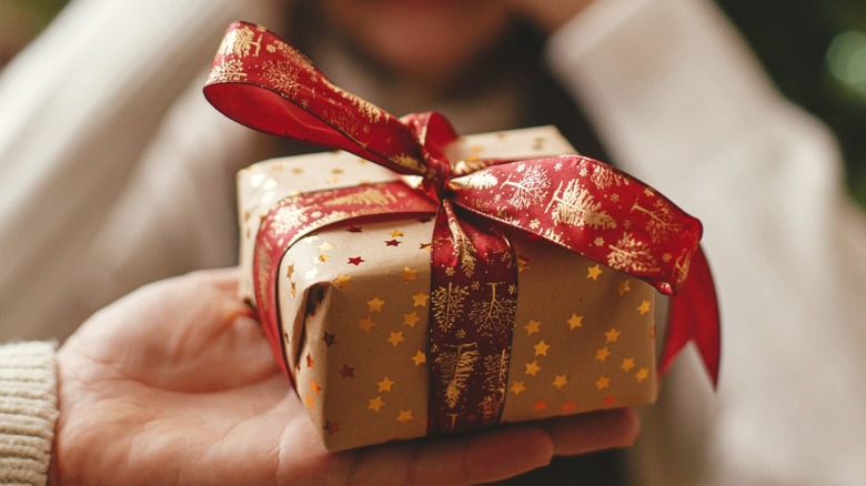 Hand holding wrapped holiday gift