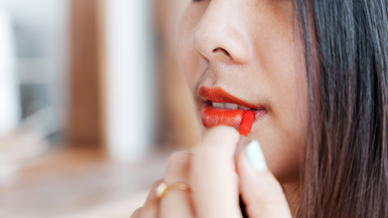 woman applying red lipstick