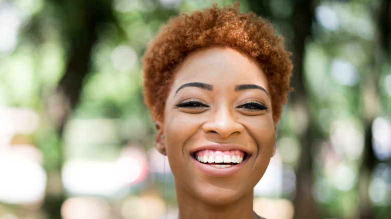Woman smiling curly auburn hair