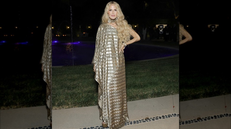 Rachel Zoe posing in a golden gown with metallic details.