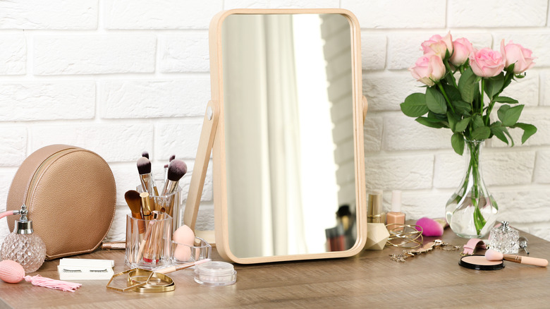 dresser with makeup brushes and flowers