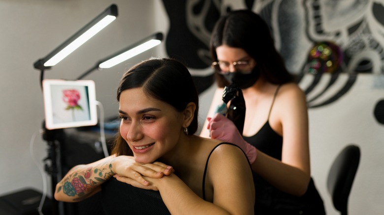 woman getting a back tattoo