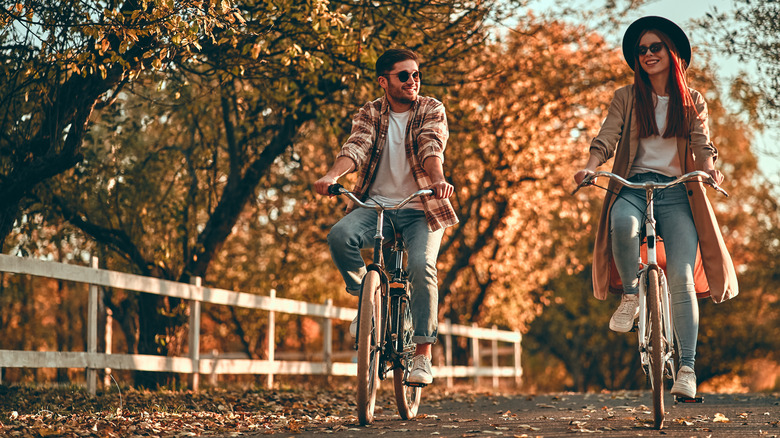 Couple cycling through trees