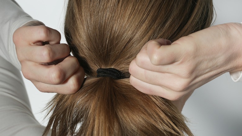 Woman tying her ponytail