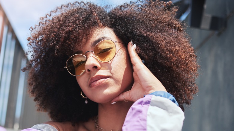 A cool woman with a side part in her curly hair.