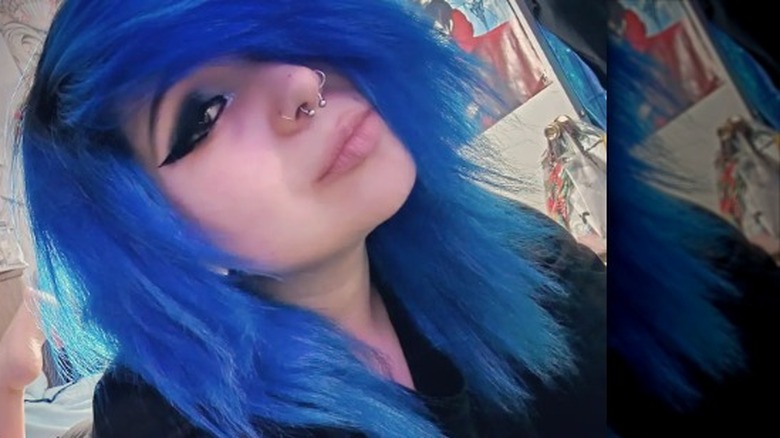 Girl with bright blue hair and nose piercings