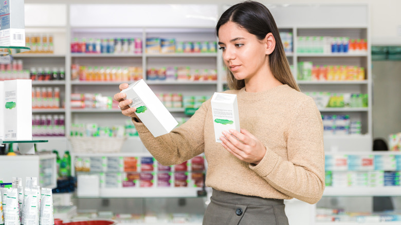 Woman reading the labels on skincare products