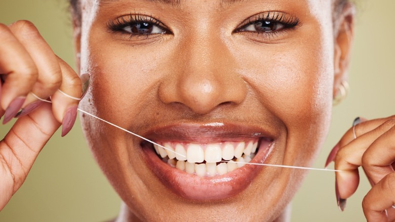 Woman smiling and flossing