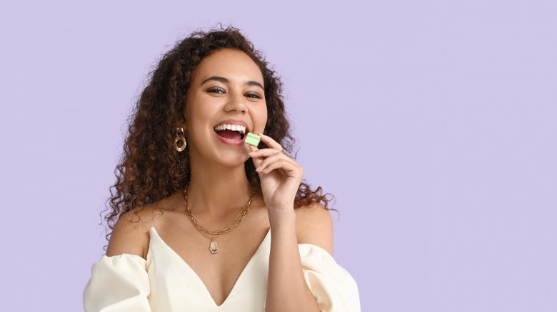 Woman putting gum in mouth