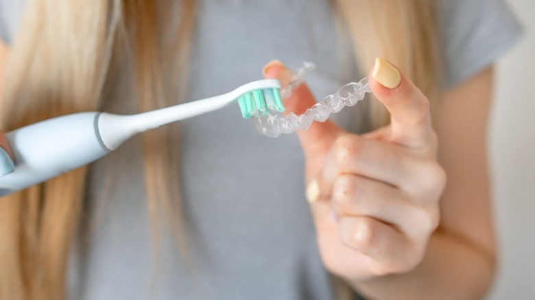 Cleaning clear aligner with toothbrush