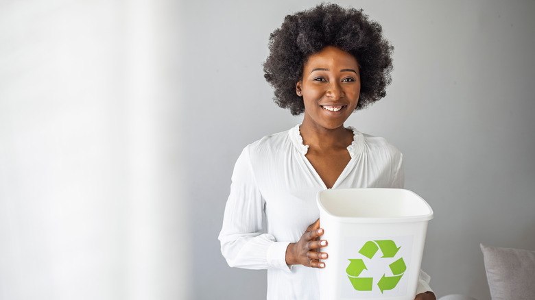 woman holding a recycling bin