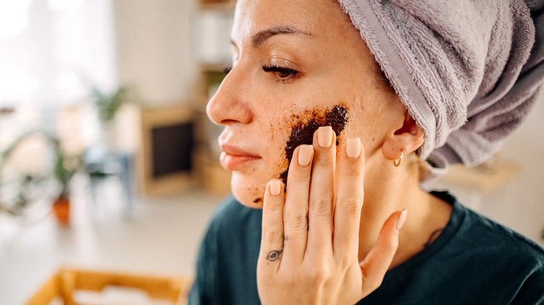 woman exfoliating face