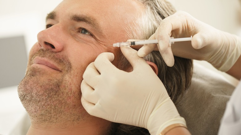 Man receiving injection around eyes 