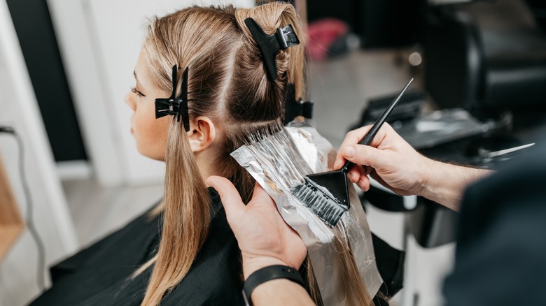 Woman getting highlights with bleach