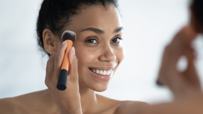 Woman using makeup brush