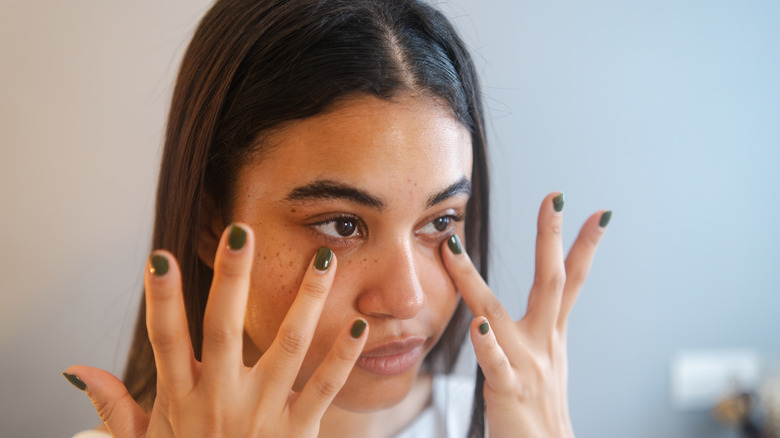 Woman applying product to lower lids